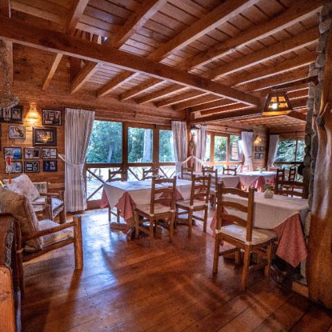 Salón desayunador con hogar a leña y vista al parque en Pichi Rincón